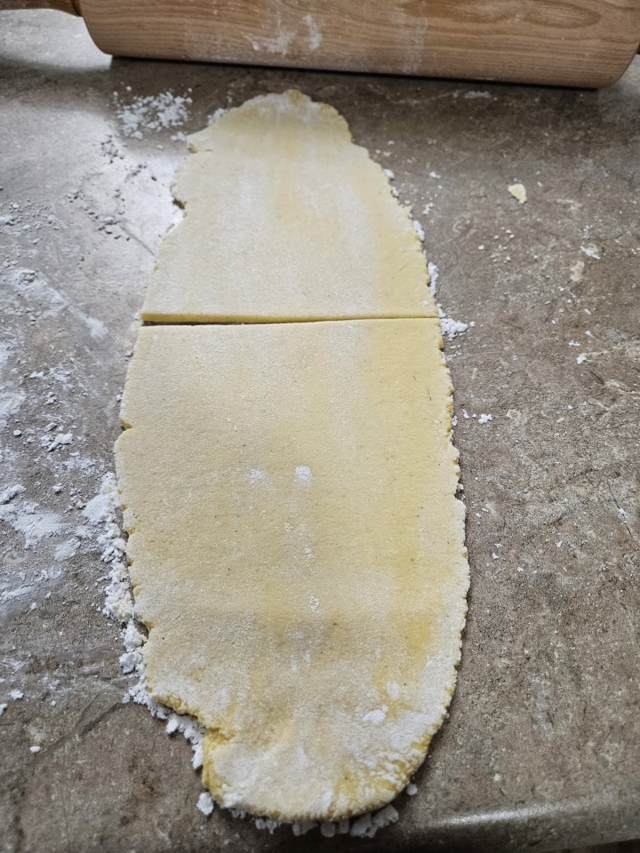 gluten-free pasta rolled out on counter top with rolling pin