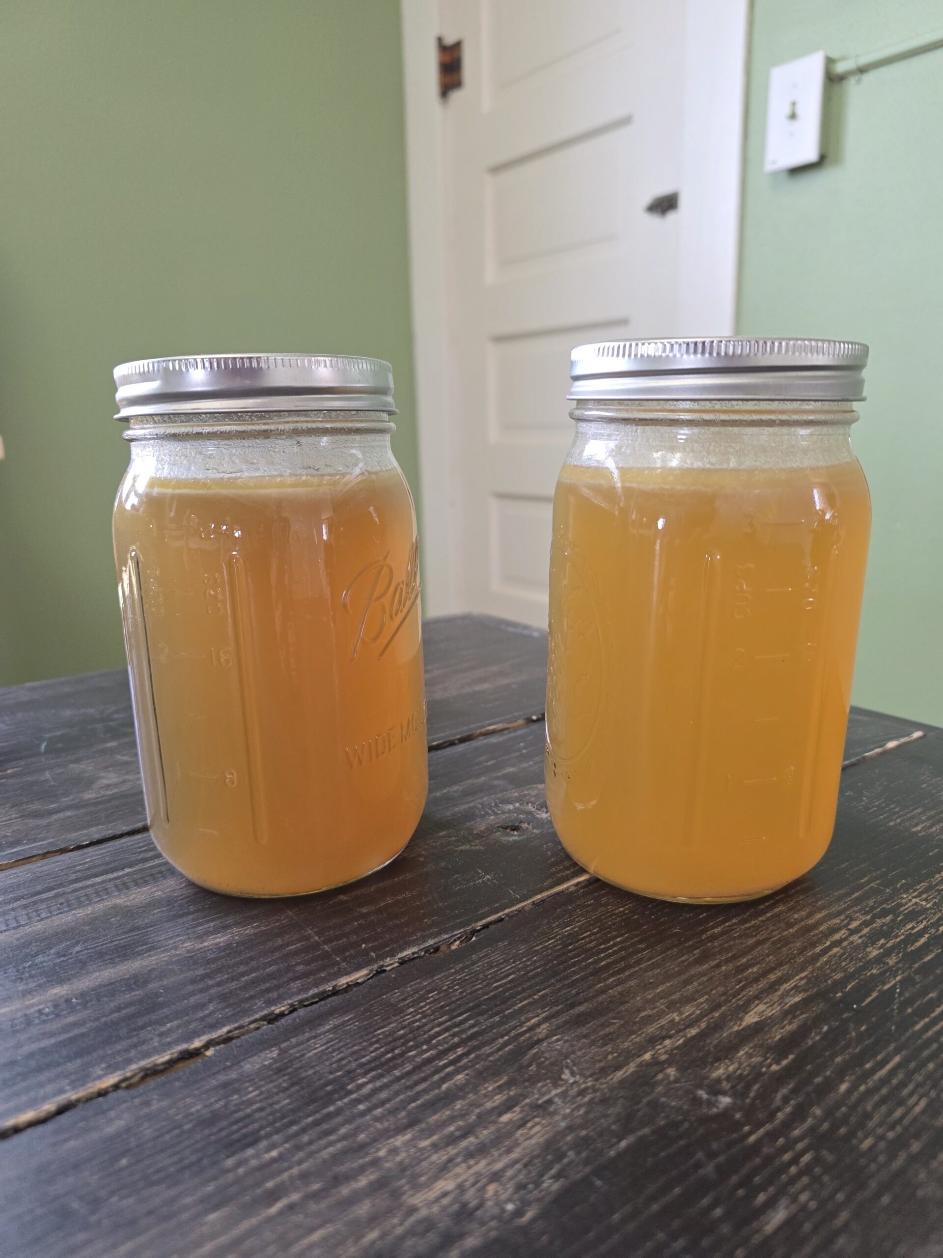 chicken broth showing how one jar of broth is more diluted than the first jar in the picture (on the left), diluted jar is on the right