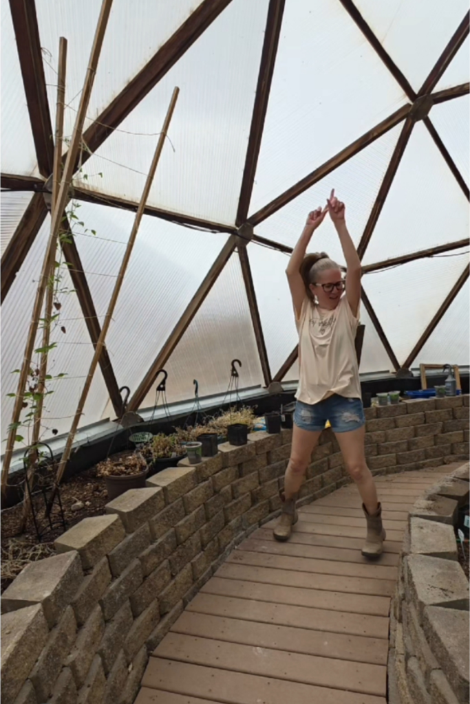 a woman dancing in a greenhouse