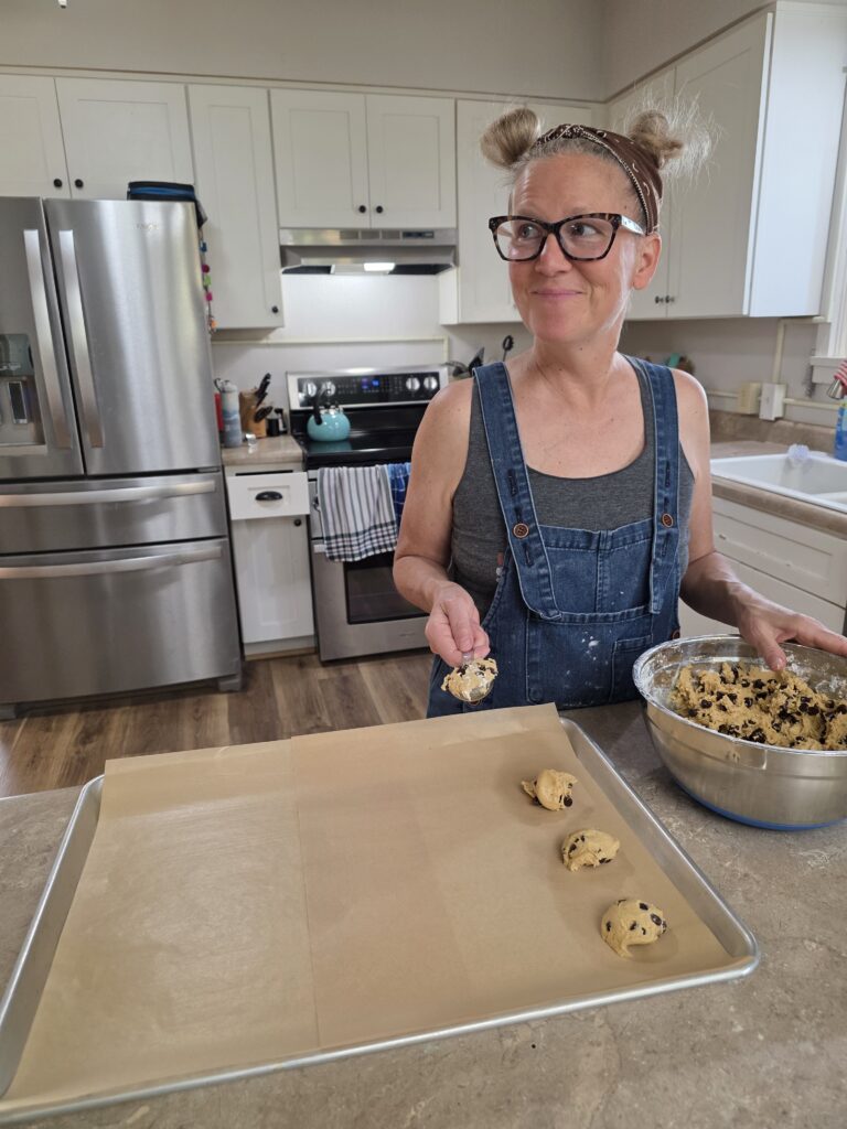 picture of woman dropping spoonfuls of cookie dough on a cookie sheet